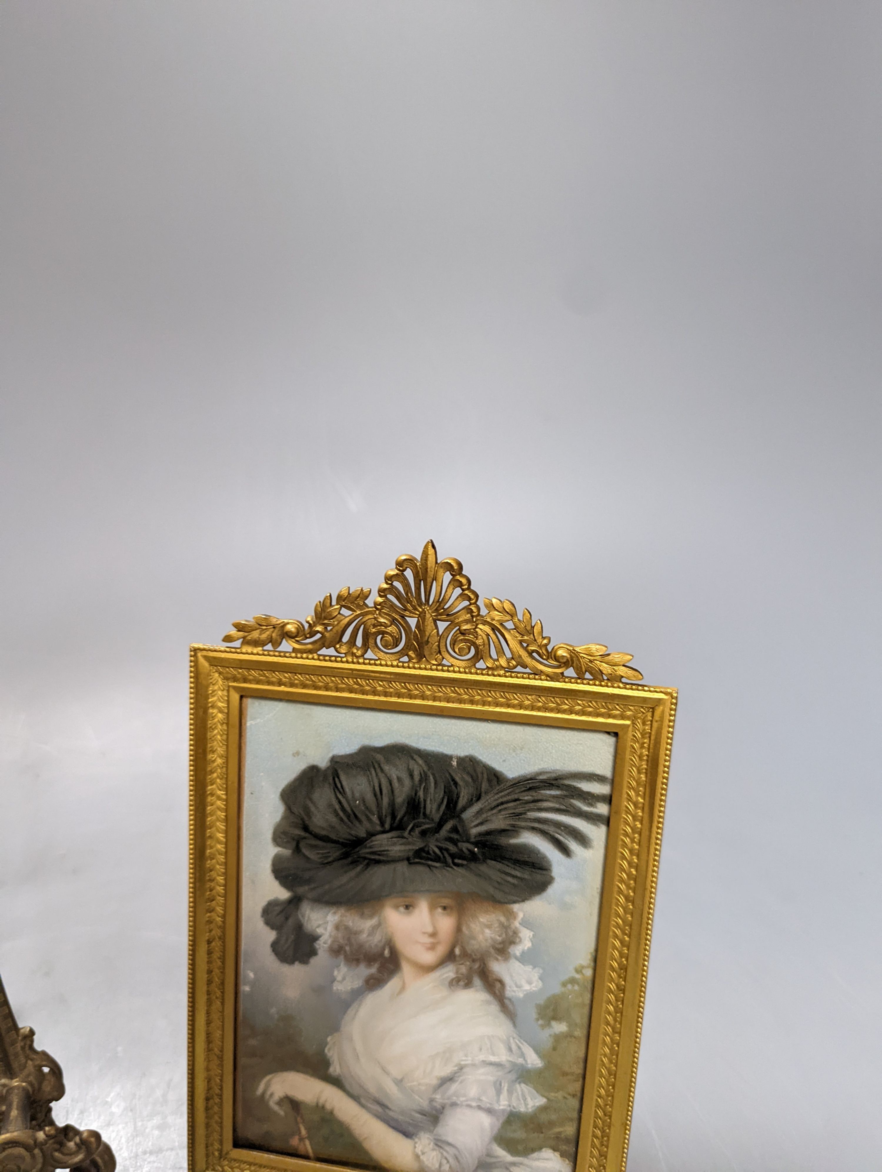 Victorian miniature print of a lady in a black feather hat in a gilt brass frame and a small brass easel, easel 25 cms high.